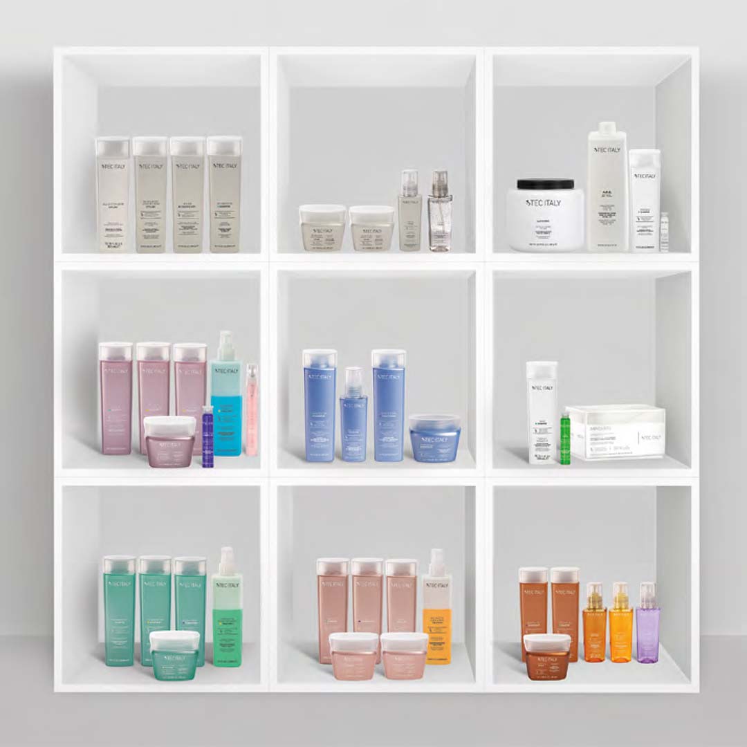 The 2021 Tec Italy products are in a colorful grouping each bottle in pastel color standing together as a family on elegant shelving and shiny packages organized by hair categories that target specific results.